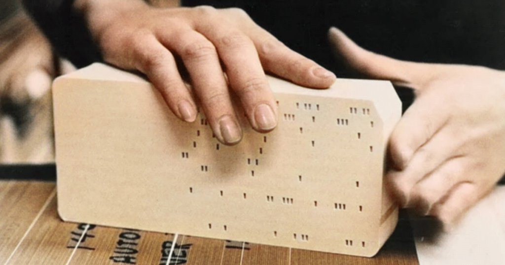 Hand holding a punched card for data input, photo