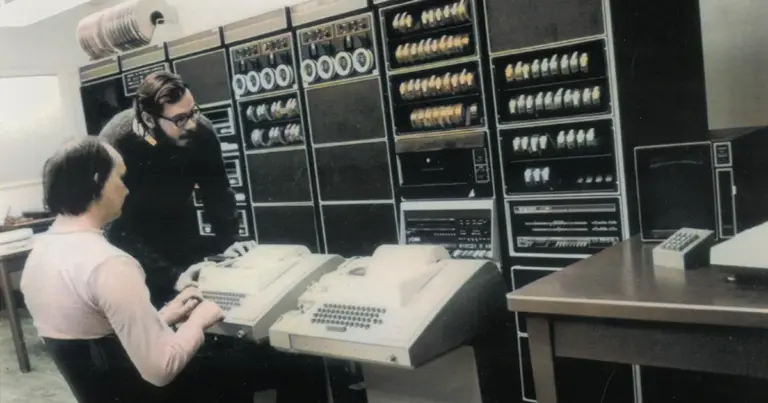 Computer engineers working on an early mainframe computer, photo